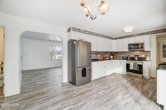 kitchen with backsplash, white cabinetry, and appliances with stainless steel finishes