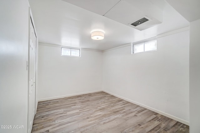 basement featuring plenty of natural light and light hardwood / wood-style floors