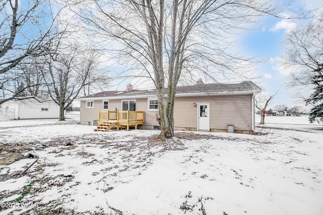 snow covered house featuring a wooden deck