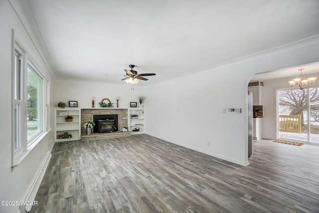 unfurnished living room with ornamental molding, ceiling fan with notable chandelier, and hardwood / wood-style floors