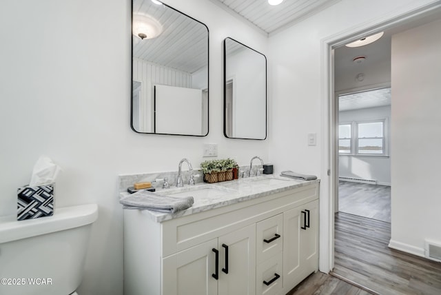 bathroom with wood-type flooring, toilet, and vanity