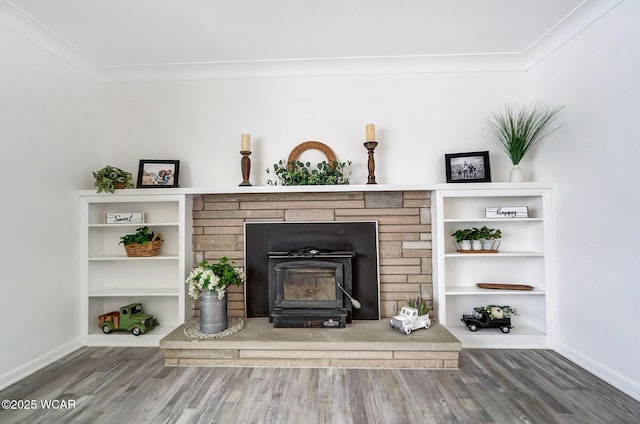 room details with built in shelves, hardwood / wood-style floors, a wood stove, and ornamental molding