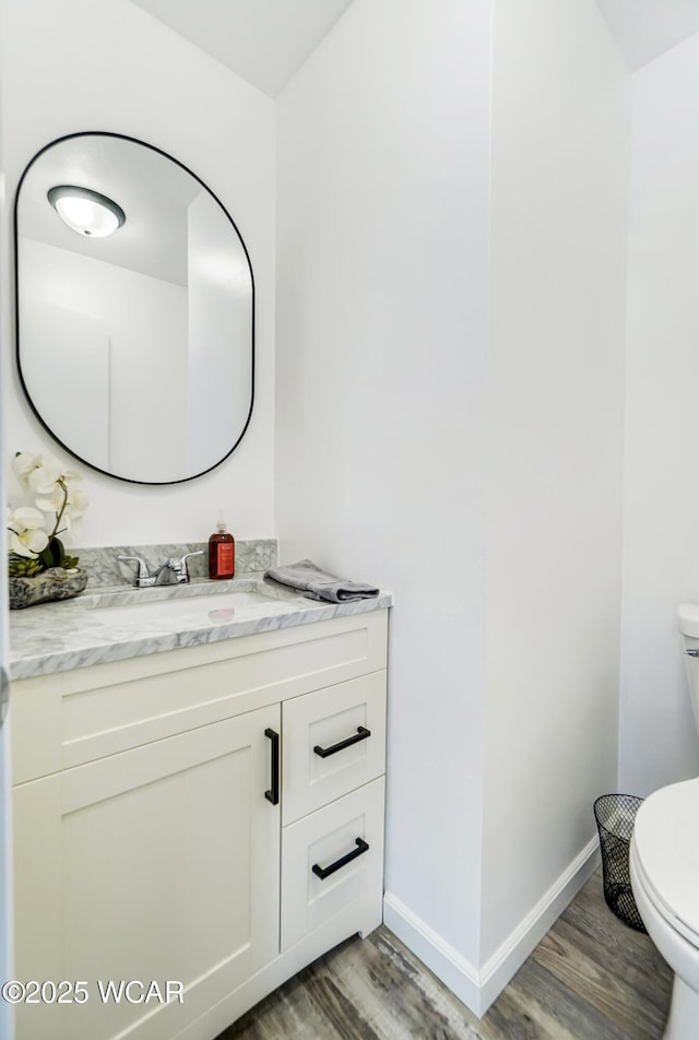 bathroom with hardwood / wood-style floors, toilet, and vanity