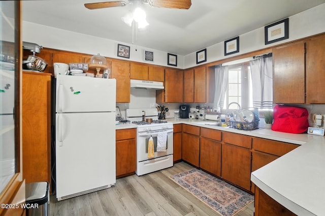 504 E 6th St, Delphos, OH 45833 - kitchen featuring white appliances, under cabinet range hood, light countertops, and brown cabinets