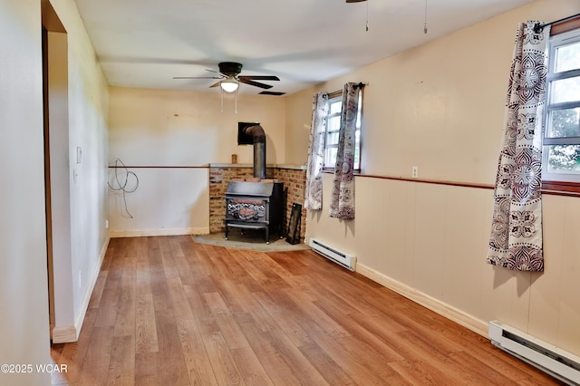 4940 Stewart Rd, Lima, OH 45801 - empty room with a baseboard radiator, ceiling fan, and a wood stove