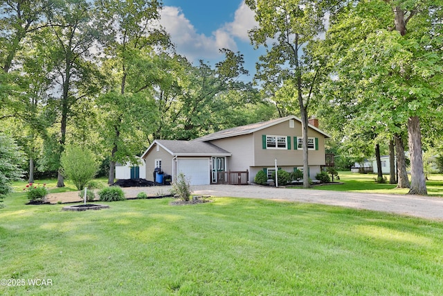 4940 Stewart Rd, Lima, OH 45801 - split level home with driveway, a chimney, an attached garage, a front lawn, and view of wooded area