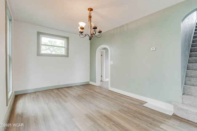 1157 W High St, Lima, OH 45805 - unfurnished room with arched walkways, stairs, light wood-type flooring, and a chandelier