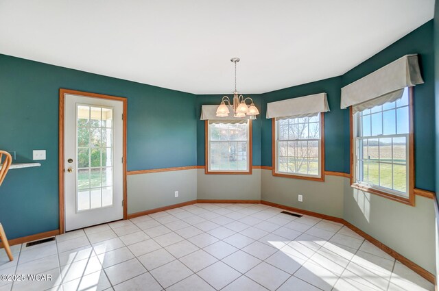 unfurnished dining area with baseboards, visible vents, a notable chandelier, and light tile patterned floors