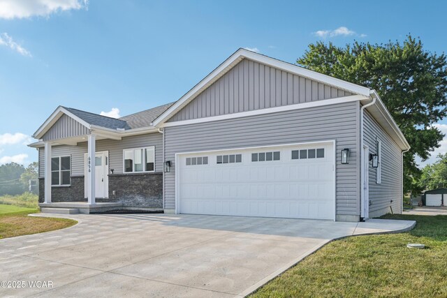 6856 Creekview Ct, Huntsville, OH 43324 - view of front of home featuring driveway, an attached garage, a front lawn, stone siding, and central air condition unit