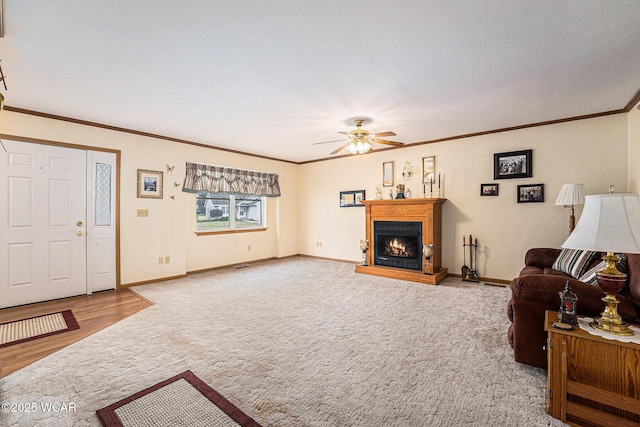 354 Stone Hedge Ln, Kenton, OH 43326 - living area featuring carpet floors, ceiling fan, a lit fireplace, crown molding, and wood finished floors