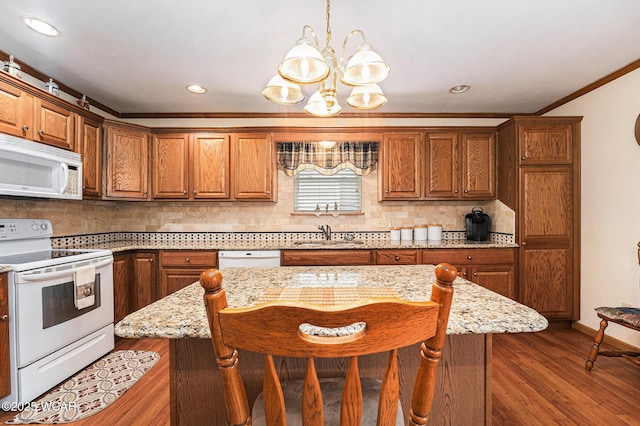354 Stone Hedge Ln, Kenton, OH 43326 - kitchen with white appliances, ornamental molding, a chandelier, decorative backsplash, and brown cabinets