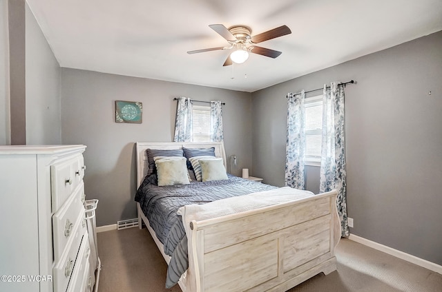 carpeted bedroom with multiple windows and ceiling fan