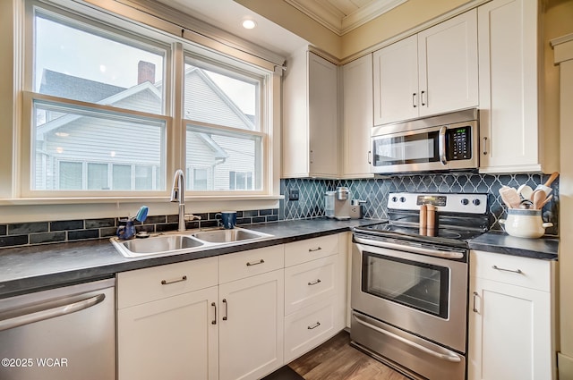 kitchen with stainless steel appliances, sink, decorative backsplash, and white cabinets