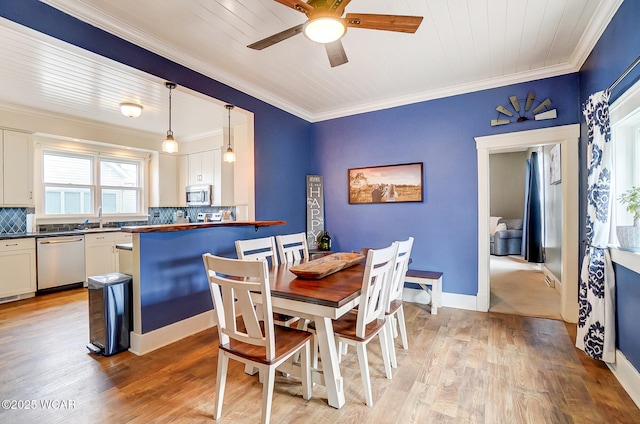 dining space featuring sink, wood ceiling, ceiling fan, ornamental molding, and light hardwood / wood-style floors