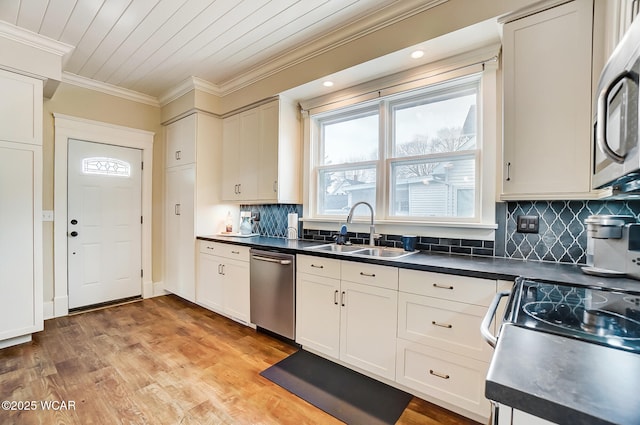 kitchen featuring white cabinetry, sink, ornamental molding, and stainless steel appliances