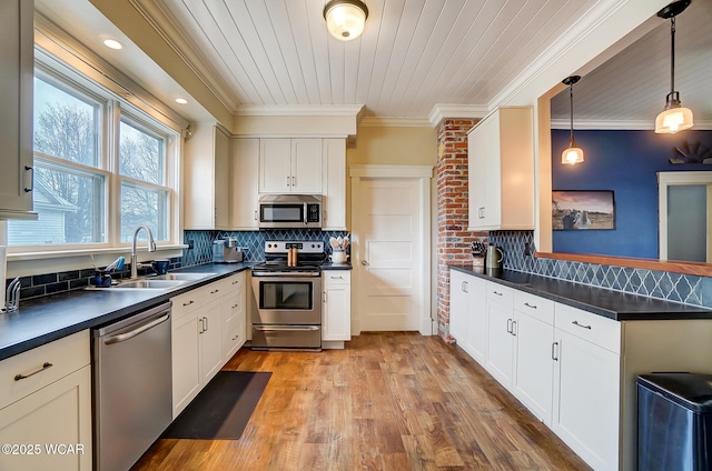 kitchen with pendant lighting, stainless steel appliances, sink, and backsplash