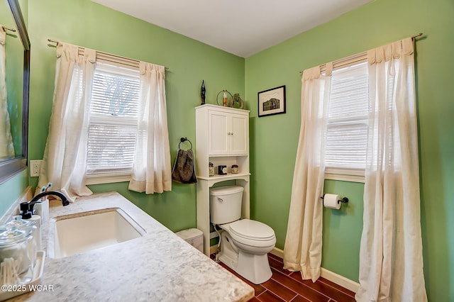 bathroom featuring wood-type flooring, toilet, and vanity