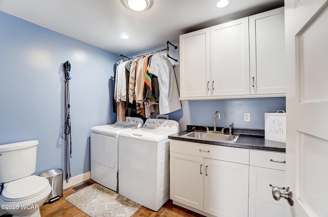 laundry area with sink, light hardwood / wood-style floors, and washing machine and dryer