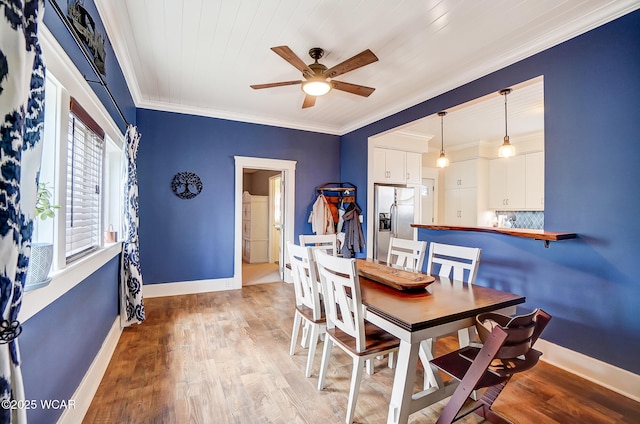 dining room with crown molding, ceiling fan, and light wood-type flooring