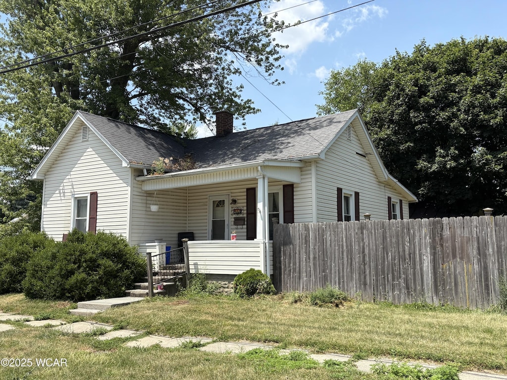411 E Sycamore St, Van Wert, OH 45891 - view of front facade featuring a chimney, covered porch, and a shingled roof