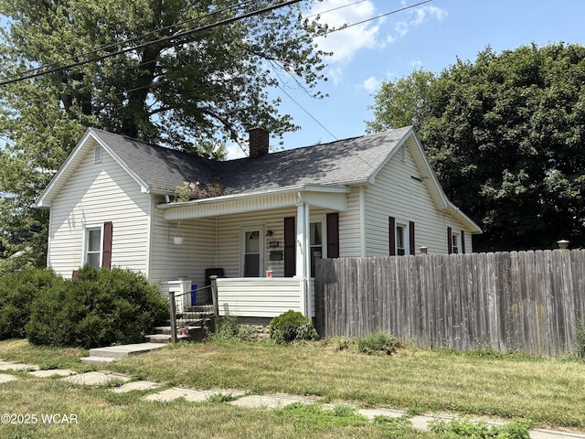 411 E Sycamore St, Van Wert, OH 45891 - view of front facade featuring a chimney, covered porch, and a shingled roof