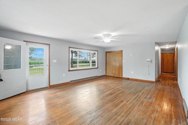 2170 E Hanthorn Rd, Lima, OH 45804 - unfurnished living room featuring baseboard heating, light wood-type flooring, and ceiling fan