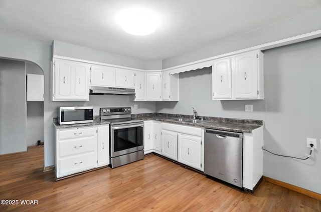 2170 E Hanthorn Rd, Lima, OH 45804 - kitchen featuring stainless steel appliances, under cabinet range hood, dark countertops, light wood-type flooring, and white cabinetry