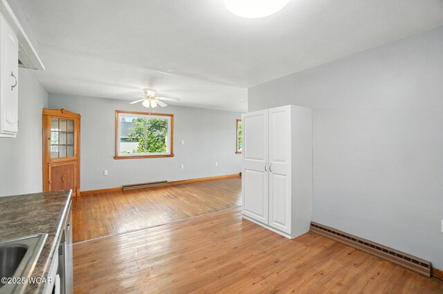 2170 E Hanthorn Rd, Lima, OH 45804 - empty room featuring a baseboard heating unit, a ceiling fan, and light wood finished floors