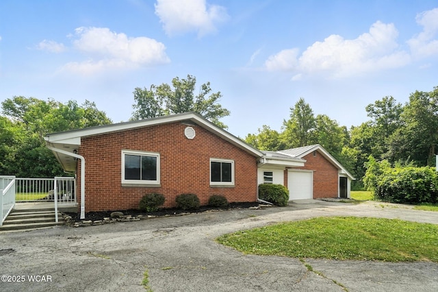 2170 E Hanthorn Rd, Lima, OH 45804 - ranch-style house featuring an attached garage, brick siding, asphalt driveway, and a metal roof