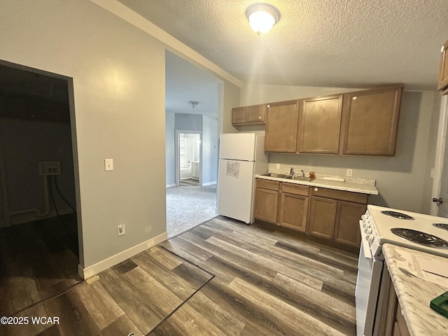 318 E E Vine St, Lima, OH 45804 - kitchen with white appliances, a textured ceiling, light countertops, a sink, and wood finished floors