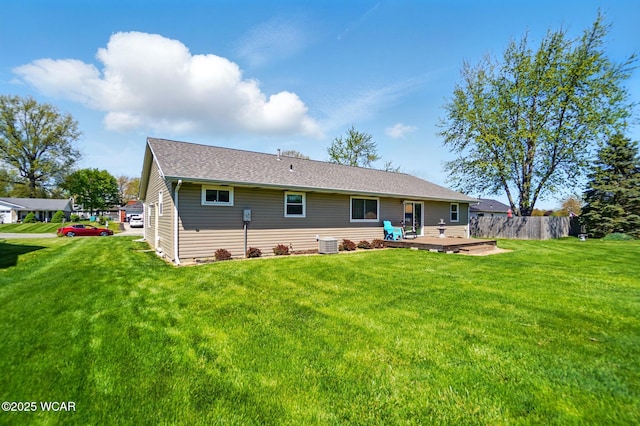 back of house with fence, cooling unit, a deck, and a lawn