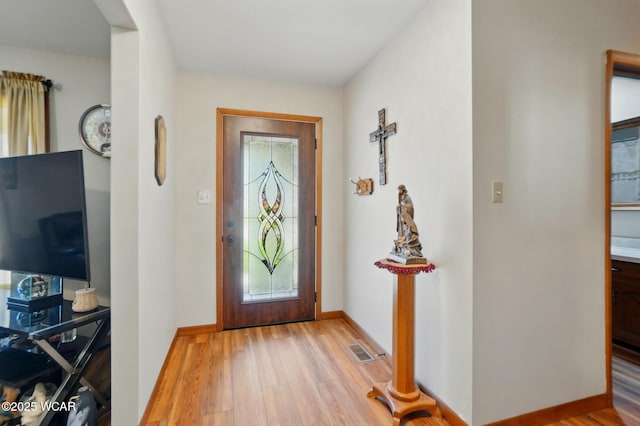 entrance foyer featuring baseboards, visible vents, and wood finished floors