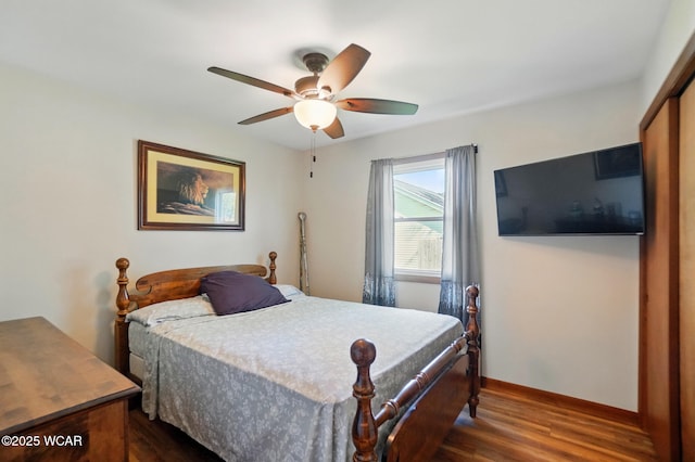 bedroom with dark wood-style flooring, baseboards, and ceiling fan