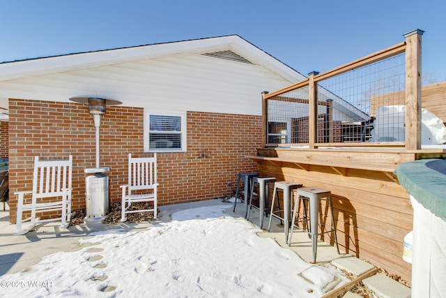 snow covered rear of property with exterior bar