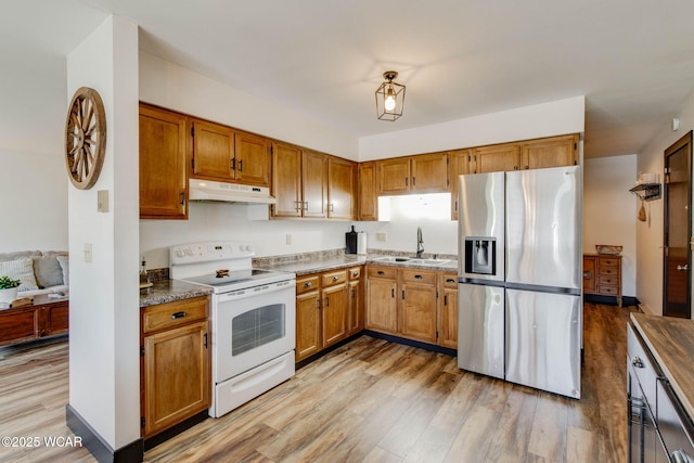 kitchen featuring stainless steel fridge, light hardwood / wood-style floors, sink, and electric range