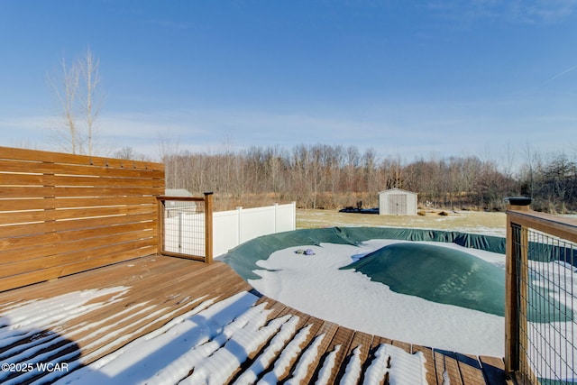 view of swimming pool with a wooden deck and a shed