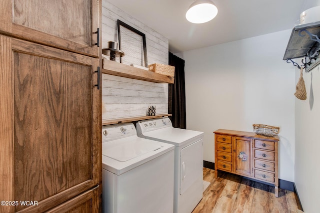 laundry room with washer and clothes dryer and light hardwood / wood-style floors