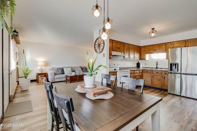 dining space featuring sink and light wood-type flooring