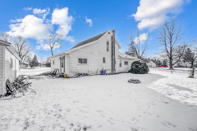 view of snow covered back of property