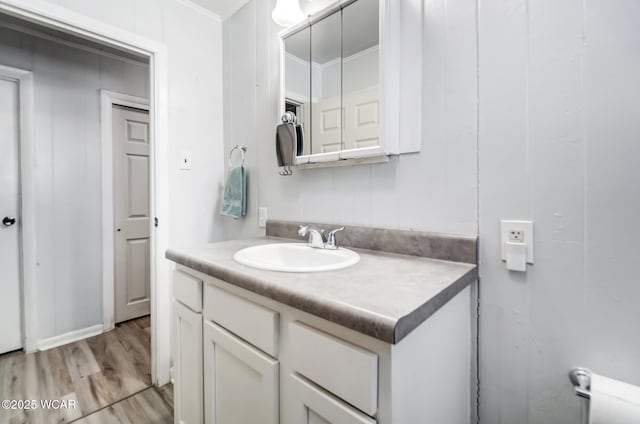 bathroom featuring vanity, hardwood / wood-style flooring, and ornamental molding