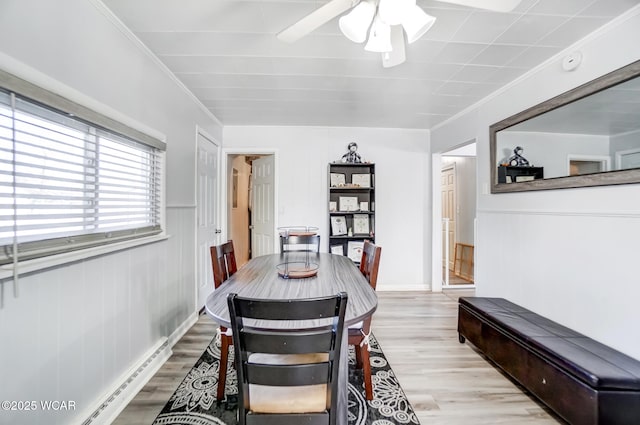 dining area featuring crown molding, ceiling fan, light wood-type flooring, and baseboard heating