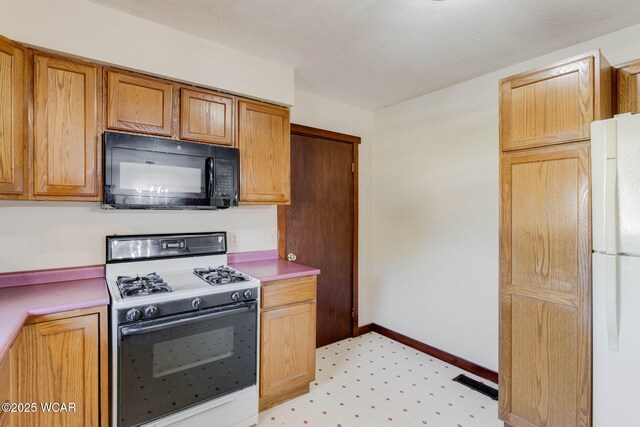 350 W Highland Ave, Ada, OH 45810 - kitchen with gas range, black microwave, freestanding refrigerator, and light countertops