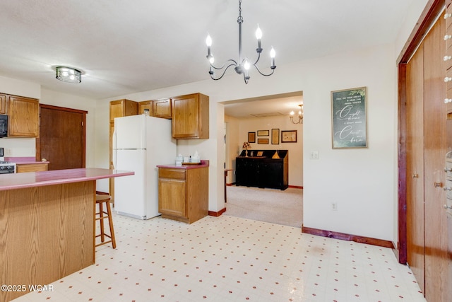 350 W Highland Ave, Ada, OH 45810 - kitchen with freestanding refrigerator, a chandelier, brown cabinetry, a kitchen breakfast bar, and black microwave