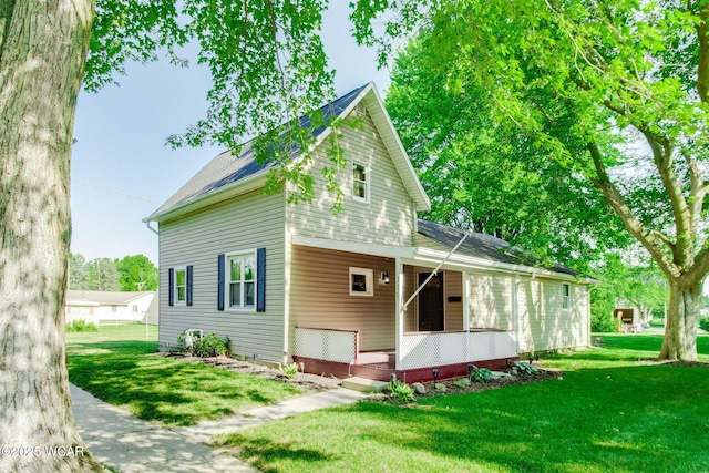 350 W Highland Ave, Ada, OH 45810 - view of front of home with covered porch, a front yard, and a shingled roof