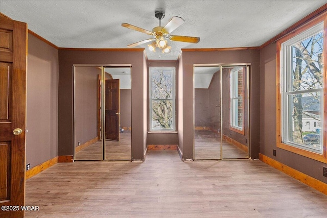 424 N Market St, Kenton, OH 43326 - unfurnished bedroom featuring light wood-type flooring, baseboards, two closets, and crown molding