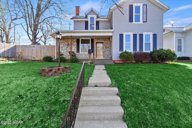 424 N Market St, Kenton, OH 43326 - traditional-style home with stone siding, a chimney, covered porch, fence, and a front yard