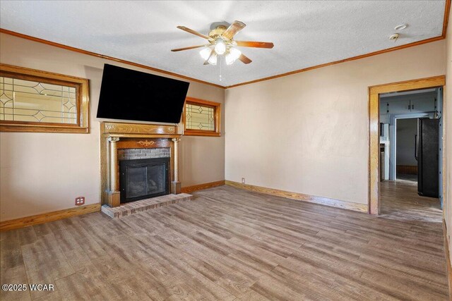 424 N Market St, Kenton, OH 43326 - unfurnished living room featuring baseboards, a brick fireplace, wood finished floors, ceiling fan, and crown molding