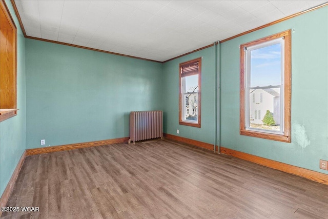 424 N Market St, Kenton, OH 43326 - empty room with radiator heating unit, baseboards, wood finished floors, and crown molding