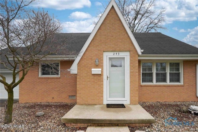 view of front of property with brick siding and roof with shingles