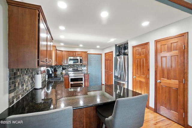 13286 Arrowhead Dr, Findlay, OH 45840 - kitchen featuring stainless steel appliances, a peninsula, tasteful backsplash, light wood-type flooring, and recessed lighting